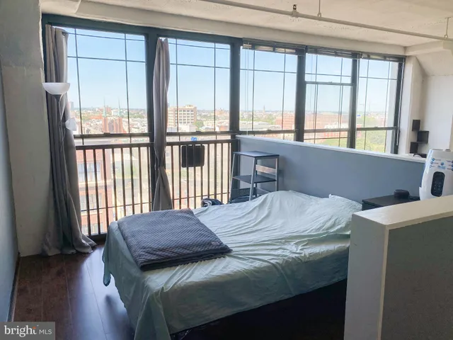a bedroom with a bed and a large window