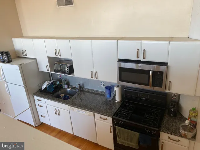 a kitchen with granite countertop a stove and a microwave