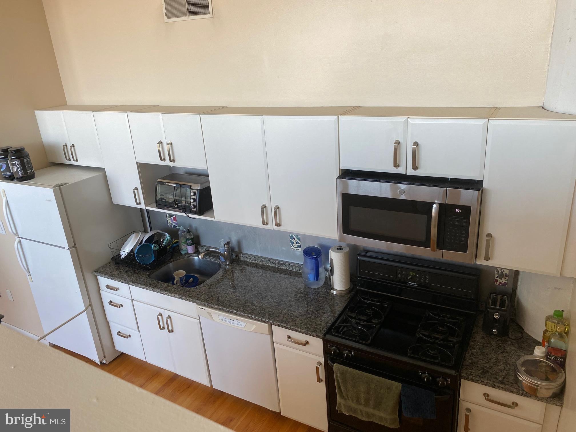 314 North 12th Street, Unit 901 Philadelphia, PA 19107 - Photo 7 of 14 a kitchen with granite countertop a stove and a microwave