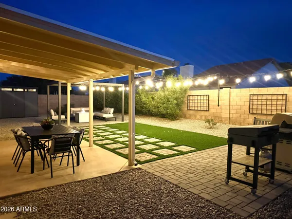 a view of a patio with table and chairs with wooden floor and fence