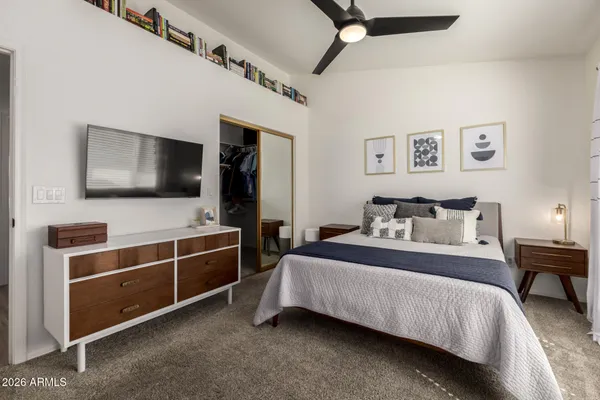 a bedroom with a bed next to a window and a desk