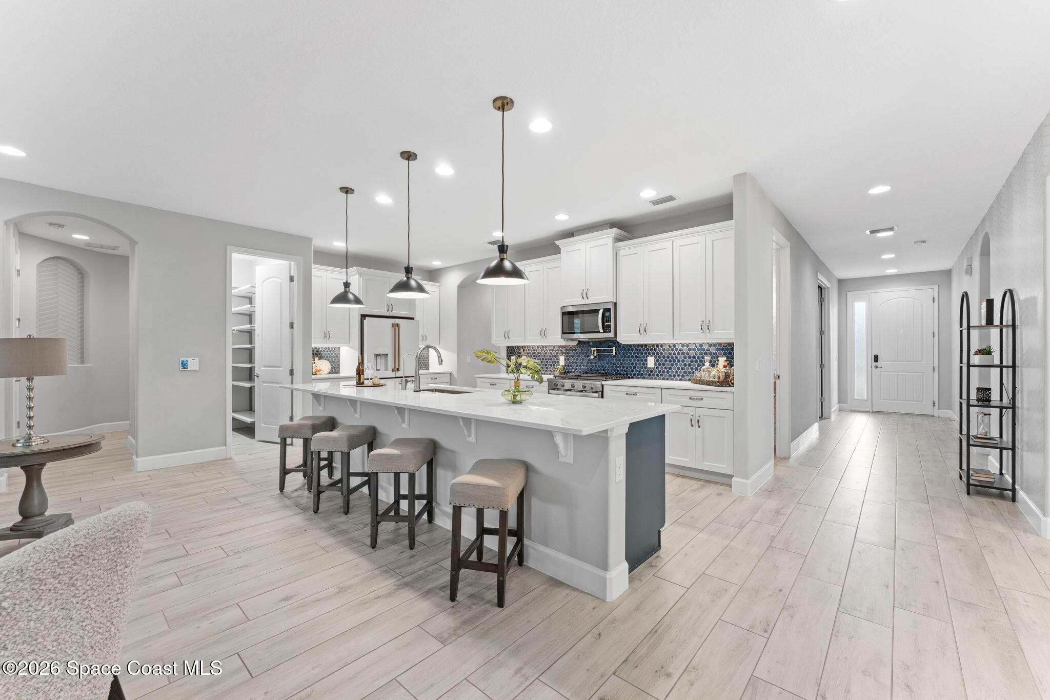 3158 Addison Drive Melbourne, FL 32940 - Photo 4 of 51 a kitchen with stainless steel appliances kitchen island granite countertop a table chairs sink refrigerator and cabinets