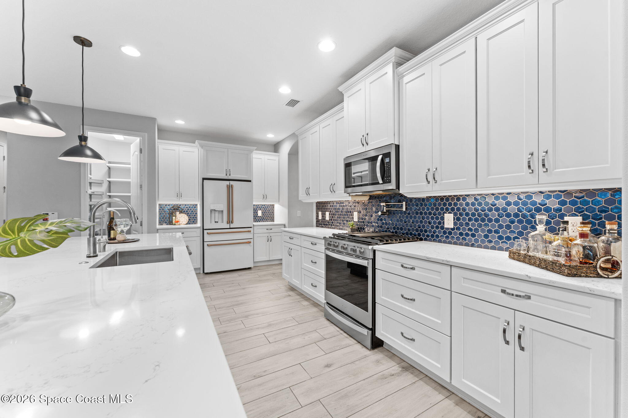 3158 Addison Drive Melbourne, FL 32940 - Photo 6 of 51 a kitchen with white cabinets and stainless steel appliances