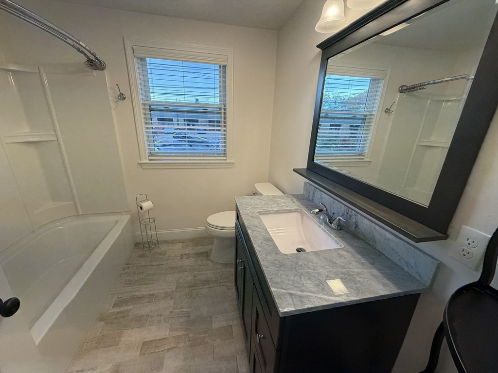 90 High Street, Unit 2 Mansfield, MA 02048 - Photo 3 of 20 a bathroom with a granite countertop sink a toilet and bathtub