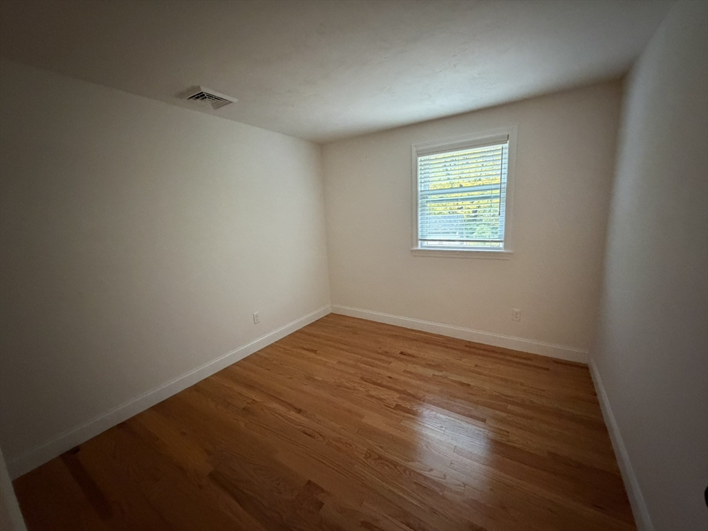 90 High Street, Unit 2 Mansfield, MA 02048 - Photo 4 of 20 a view of an empty room with wooden floor and a window