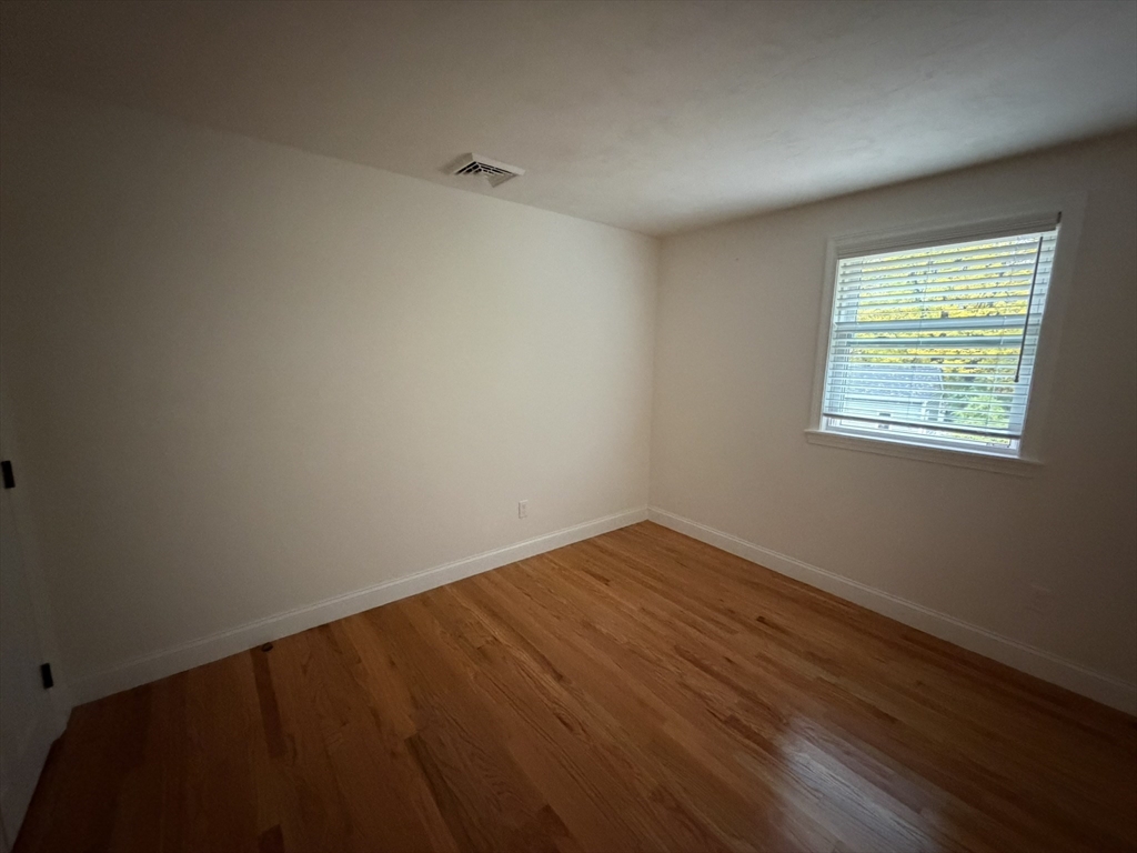 90 High Street, Unit 2 Mansfield, MA 02048 - Photo 5 of 20 a view of an empty room with wooden floor and a window