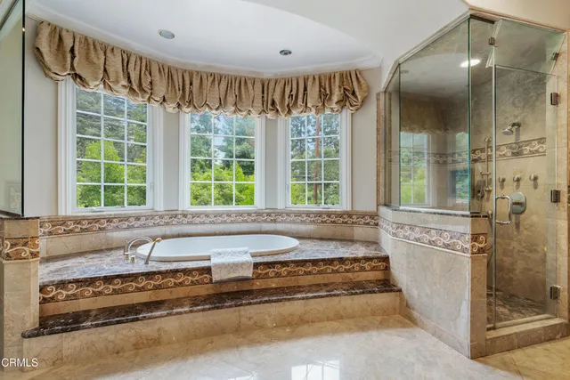 a spacious bathroom with a granite countertop tub and a large window