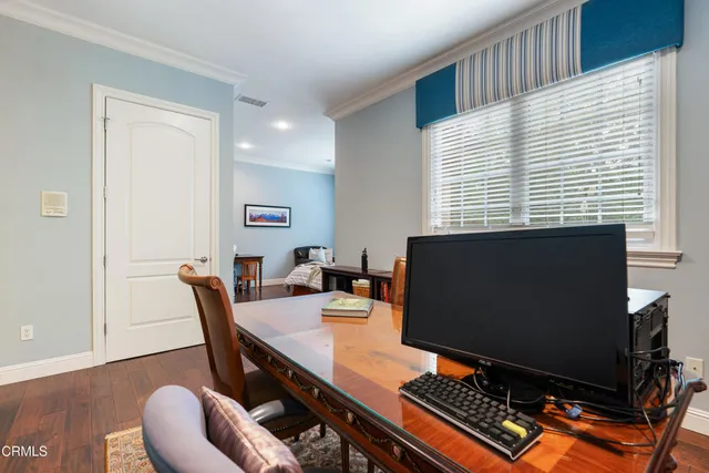 a view of a workspace with furniture and a window
