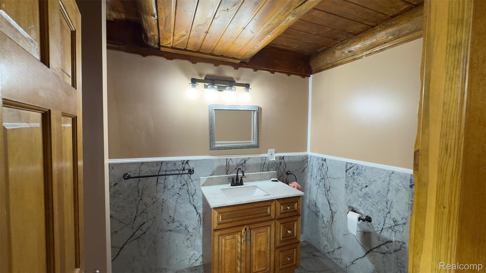 2608 East Sutton Road Metamora, MI 48455 - Photo 19 of 64 Bathroom featuring a wood-finish vanity with a light-toned countertop, a rectangular sink, and a black faucet