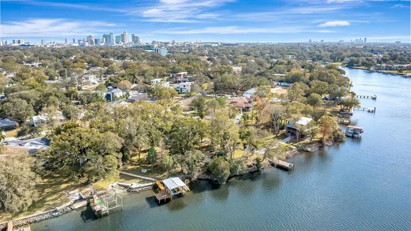 an aerial view of a house with swimming pool and lake view