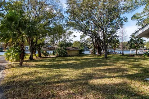 a view of yard with swimming pool and trees in the background