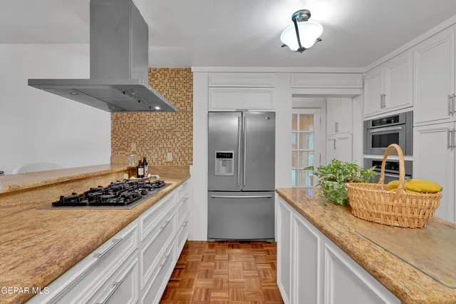 a kitchen with stainless steel appliances granite countertop a stove refrigerator and cabinets