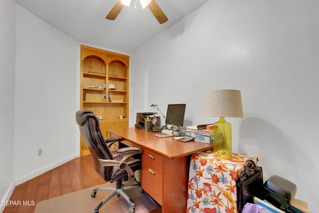 a view of a workspace with furniture and a window