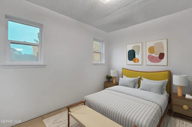 a bedroom with a bed and painting on the wall