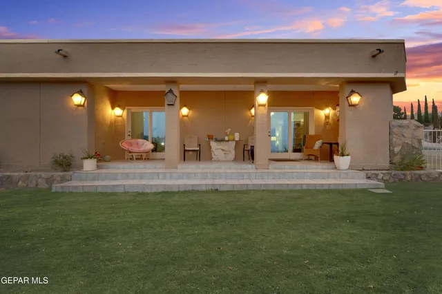 a backyard of a house with table and chairs