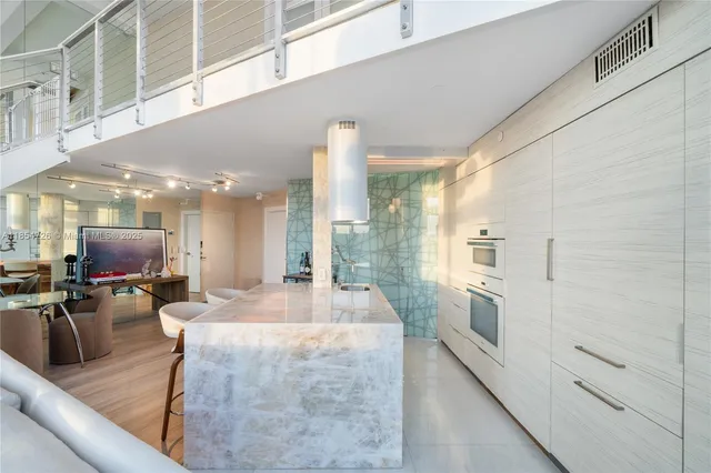 a large living room with stainless steel appliances kitchen island granite countertop a large kitchen counter top and stainless steel appliances