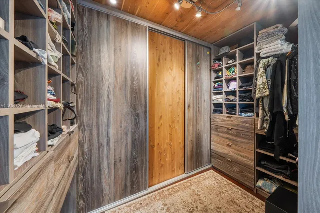 a view of walk in closet with clothes and shoes