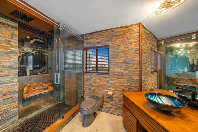 a bathroom with a sink a toilet a mirror and shower