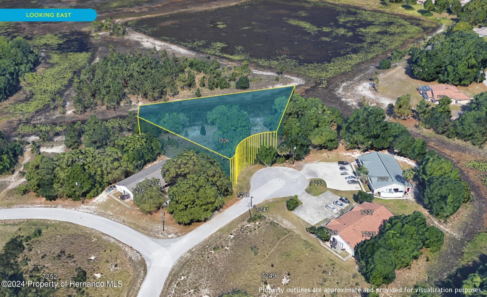 7226 Sky Court Spring Hill, FL 34606 - Photo 8 of 14 an aerial view of a house with a yard and lake
