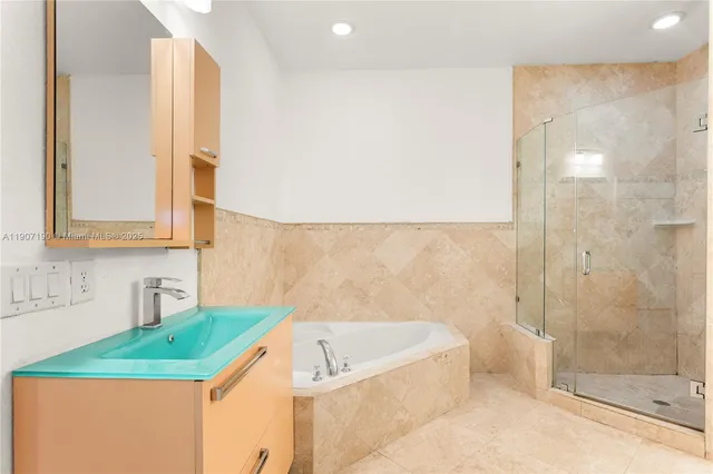 a bathroom with a tub a sink and a shower