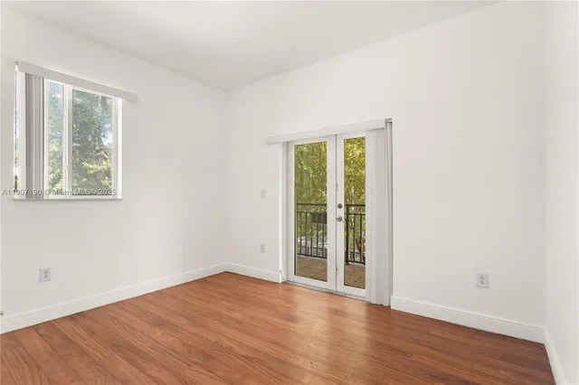 an empty room with wooden floor and a window