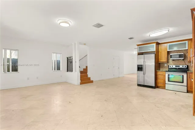 a view of an empty room with a kitchen