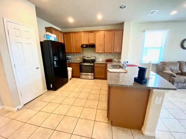 a kitchen with stainless steel appliances granite countertop a refrigerator stove and sink