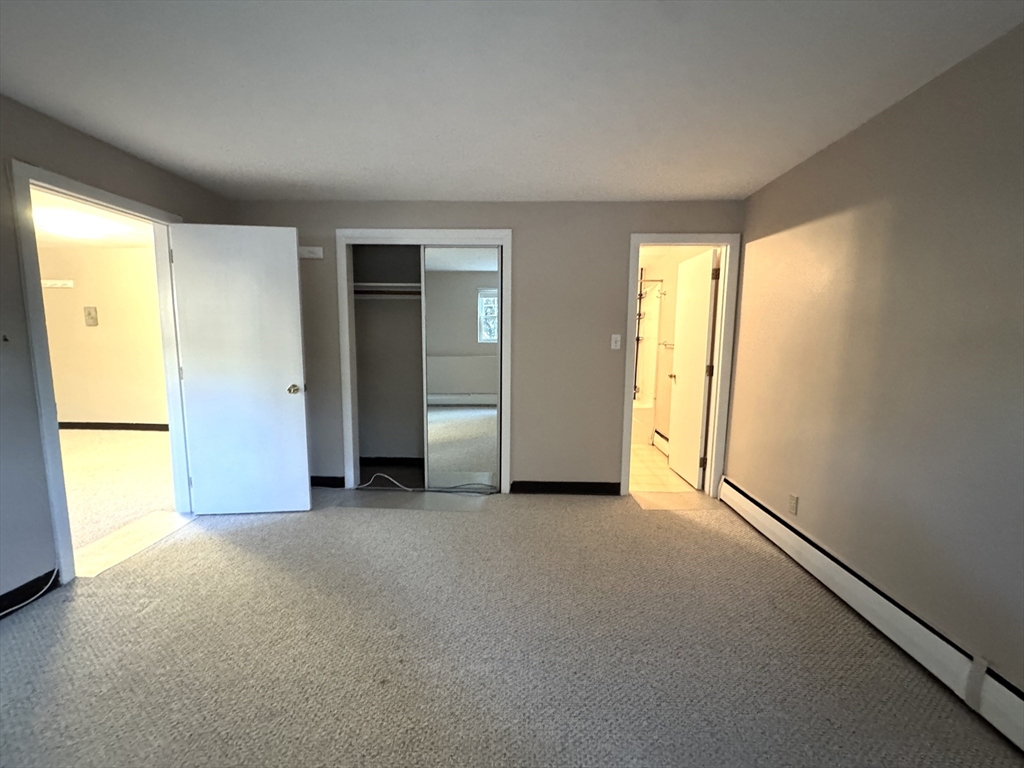 29 Arlington Road, Unit 2 Woburn, MA 01801 - Photo 4 of 11 an empty room with windows and closet