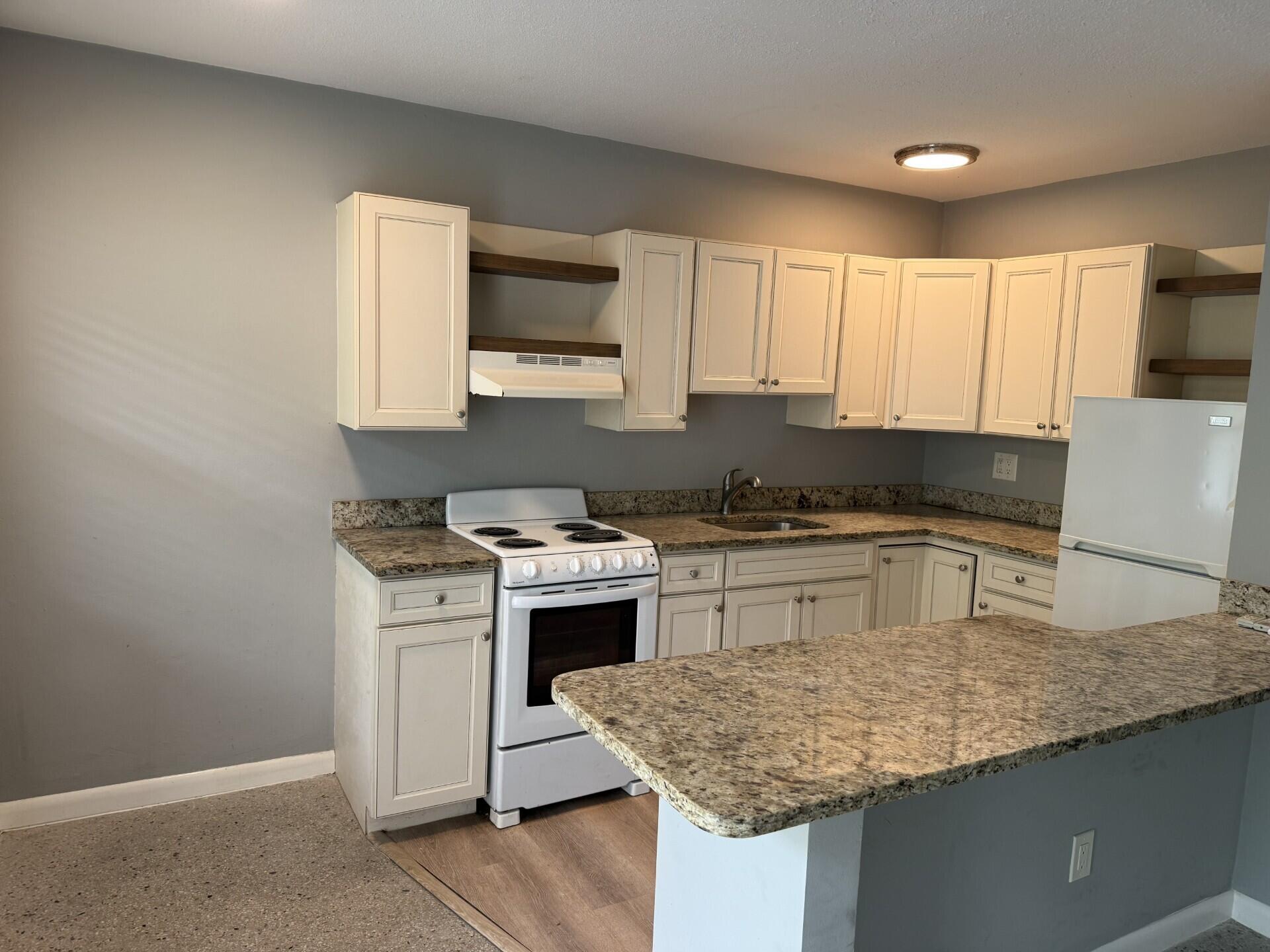 1118 North H Street, Unit 3 Lake Worth Beach, FL 33460 - Photo 3 of 11 a kitchen with granite countertop cabinets stainless steel appliances and a counter space