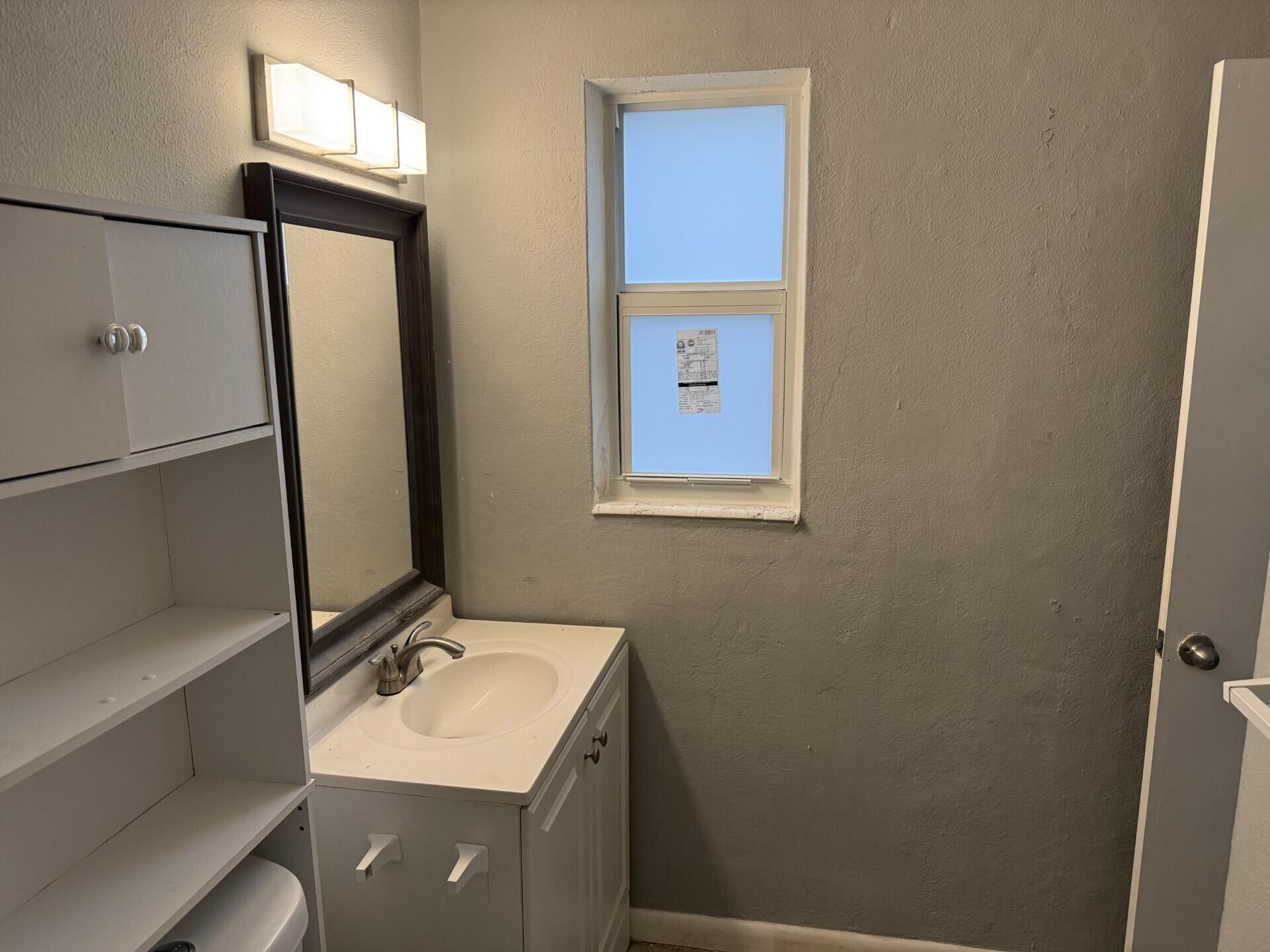 1118 North H Street, Unit 3 Lake Worth Beach, FL 33460 - Photo 6 of 11 a bathroom with a sink vanity and a mirror