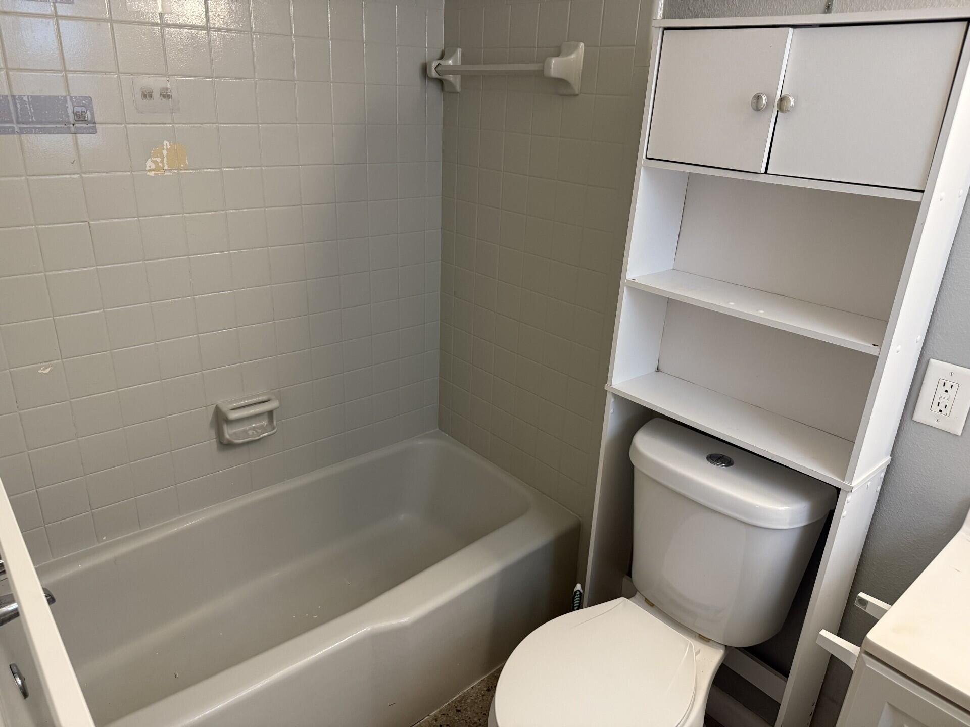 1118 North H Street, Unit 3 Lake Worth Beach, FL 33460 - Photo 7 of 11 a white toilet sitting next to a bath tub
