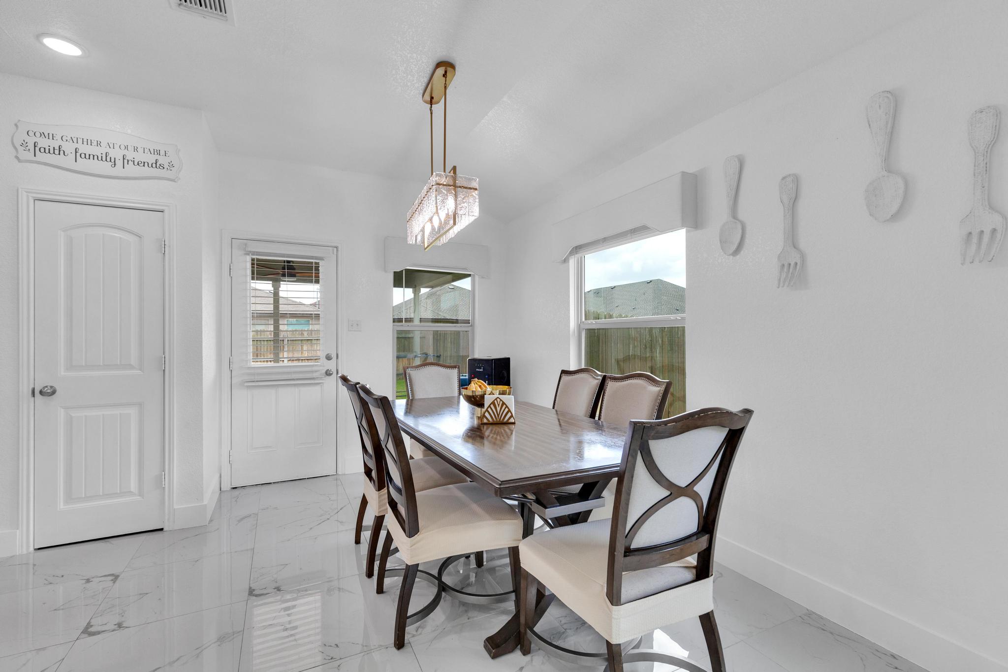 119 Beth Ann Loop Taylor, TX 76574 - Photo 11 of 31 This dining area showcases a sleek dining set, illuminated by a contemporary chandelier, perfect for intimate gatherings.