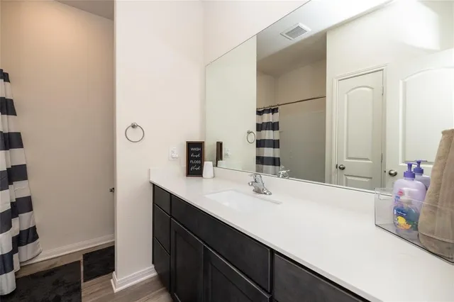 a en suite bathroom with a granite countertop sink and shower