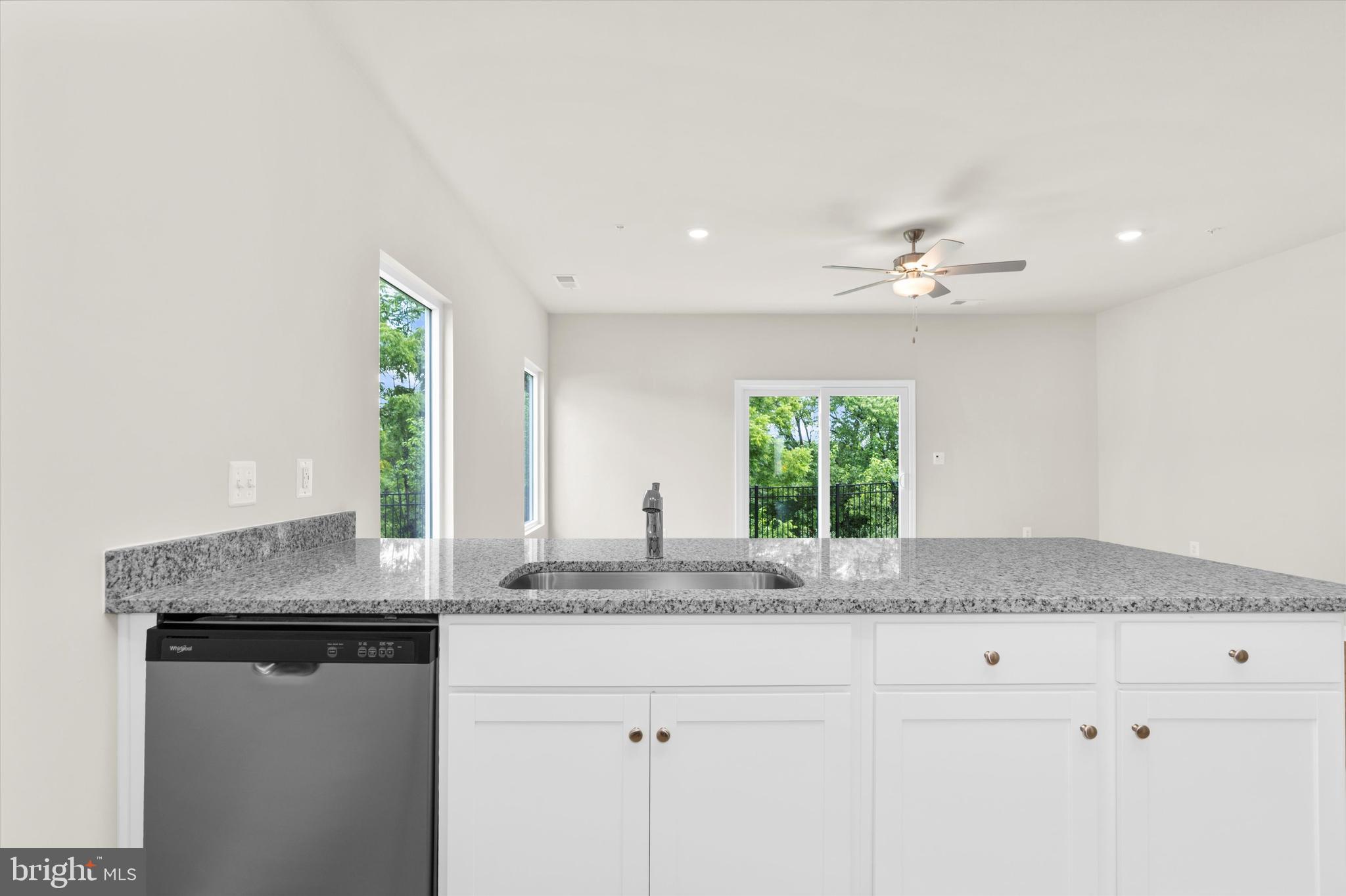 8135 Bartholomew Court Baltimore, MD 21206 - Photo 29 of 46 a kitchen with granite countertop a window a sink and white cabinets