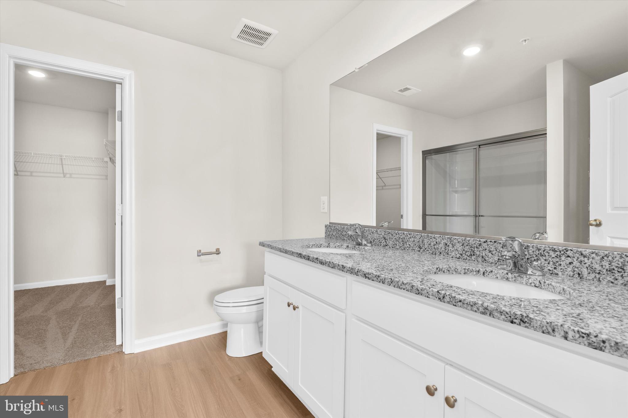 8135 Bartholomew Court Baltimore, MD 21206 - Photo 35 of 46 a bathroom with a granite countertop sink a toilet and a mirror