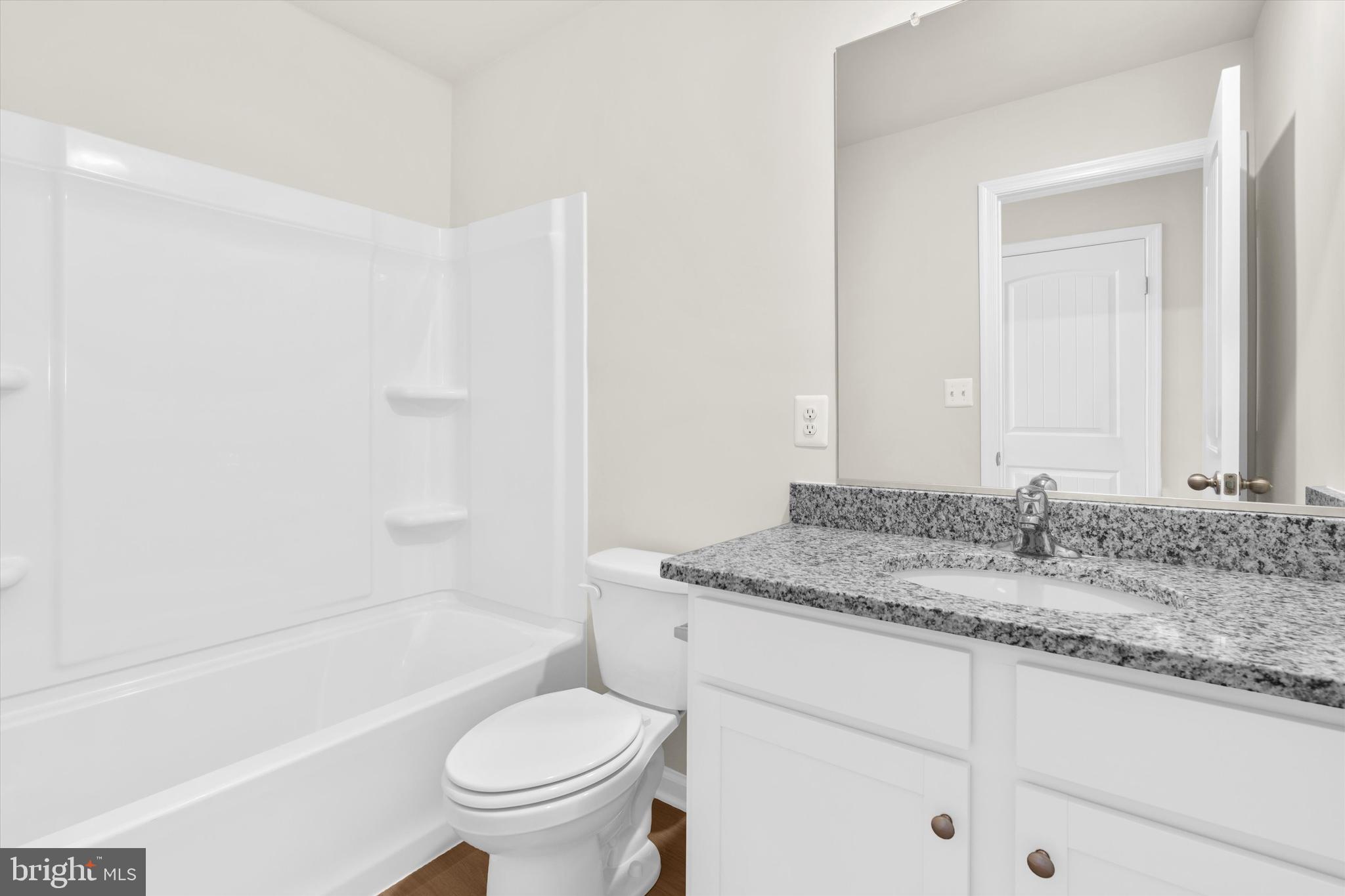 8135 Bartholomew Court Baltimore, MD 21206 - Photo 38 of 46 a bathroom with a granite countertop sink toilet and shower