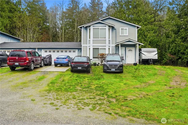 a front view of a house with a garden and parking space