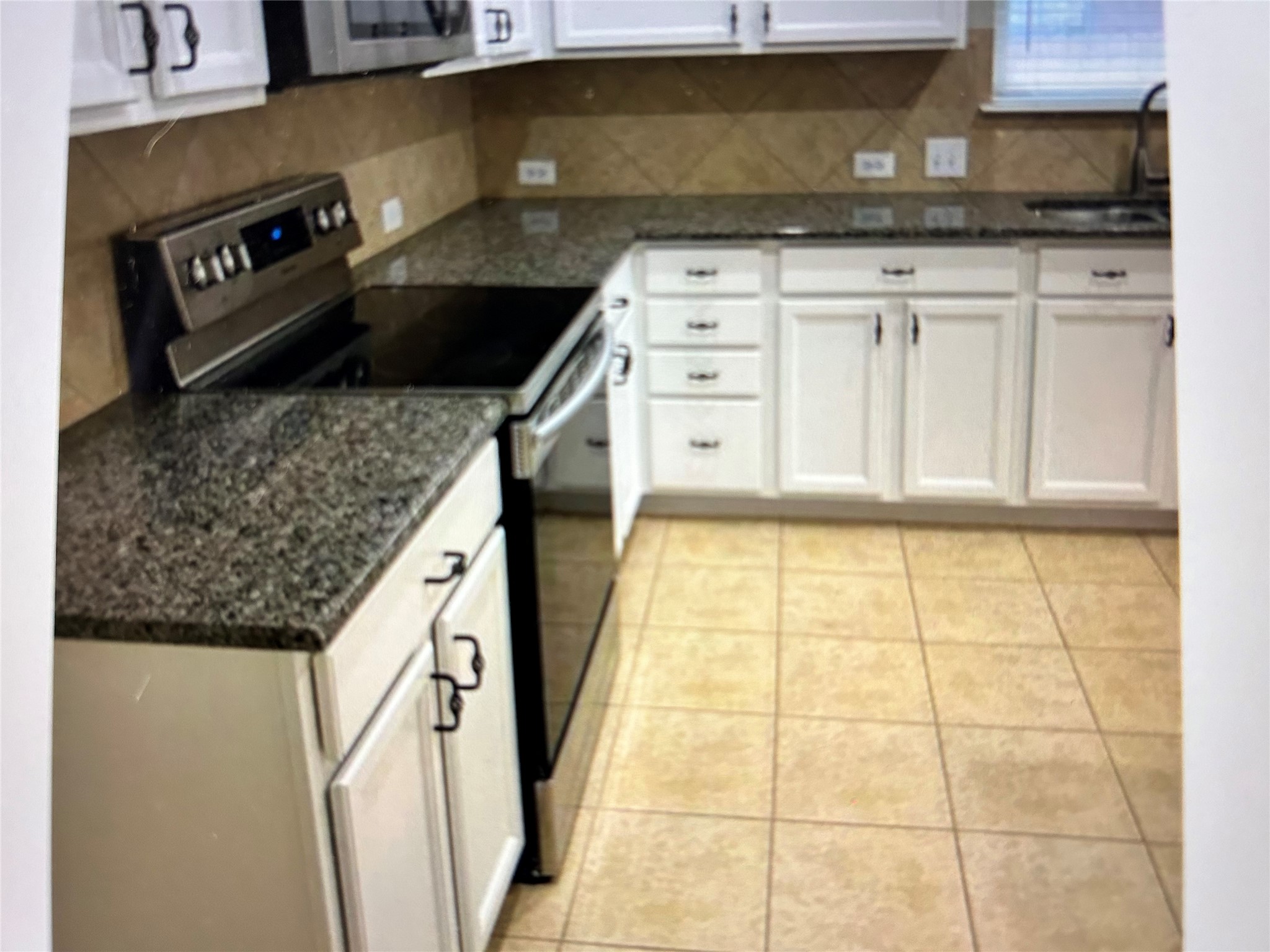 211 Animas Drive Georgetown, TX 78626 - Photo 5 of 25 a kitchen with granite countertop a stove a sink and a microwave