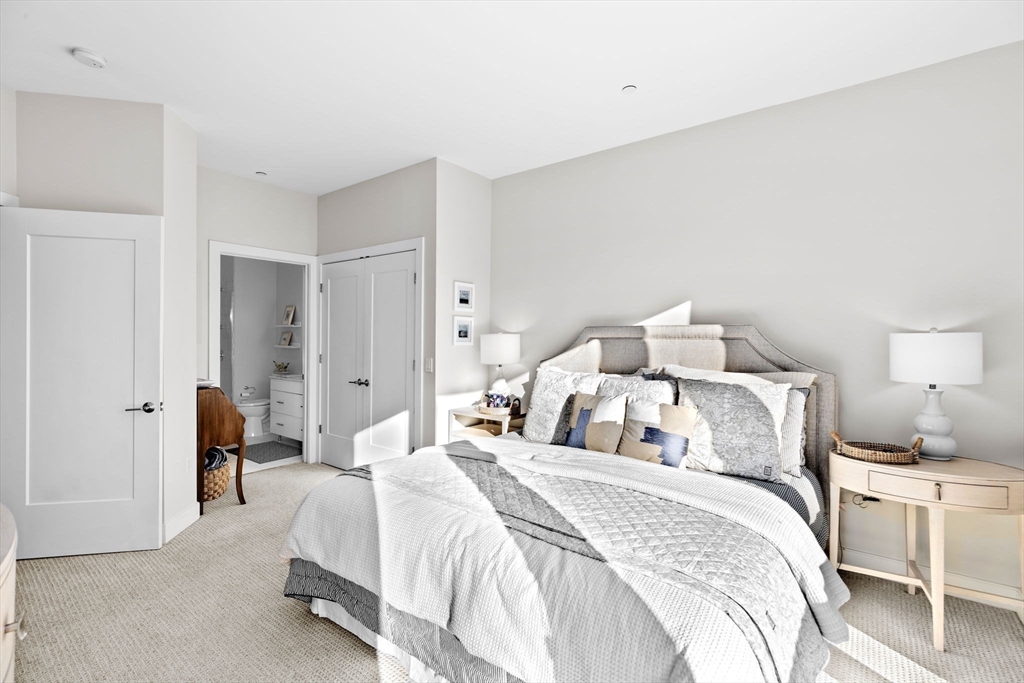 10 Shipyard Drive, Unit 215 Hingham, MA 02043 - Photo 16 of 18 a bedroom with a bed and a lamp