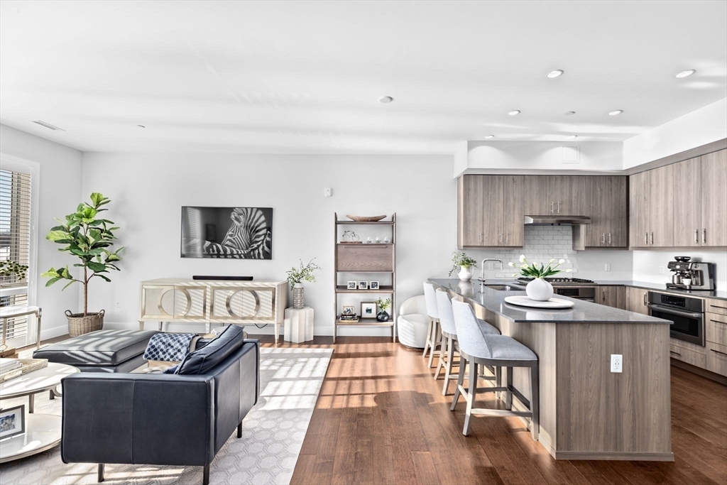 10 Shipyard Drive, Unit 215 Hingham, MA 02043 - Photo 7 of 18 a living room with stainless steel appliances a table and a couch