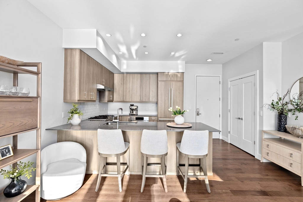 10 Shipyard Drive, Unit 215 Hingham, MA 02043 - Photo 8 of 18 a kitchen with stainless steel appliances a dining table chairs and wooden floor
