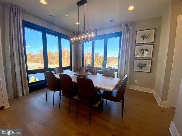 a living room with furniture kitchen view and a wooden floor