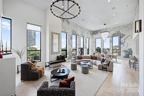 a living room with furniture fireplace and large windows