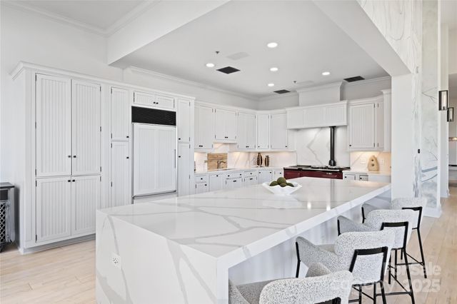 a large white kitchen with lots of counter space and windows