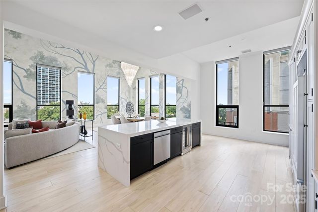 a large living room with stainless steel appliances granite countertop a large window and a couch