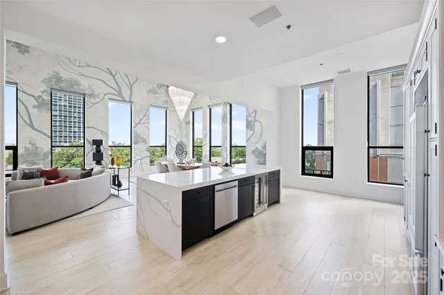 a large living room with stainless steel appliances granite countertop a large window and a couch