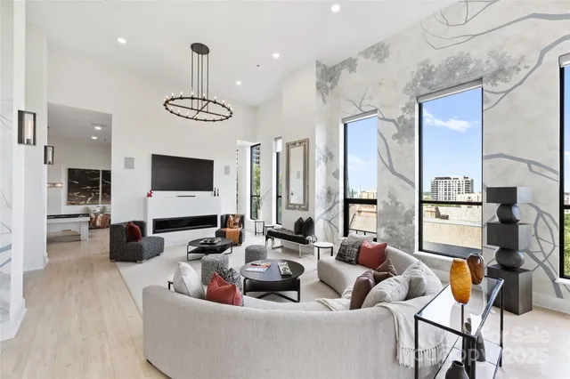 a living room with furniture kitchen view and a flat screen tv