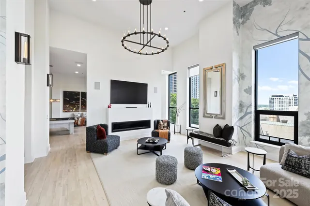 a living room with furniture a flat screen tv and kitchen view
