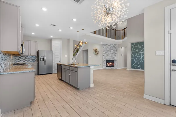 a large kitchen with a large counter top stainless steel appliances and cabinets