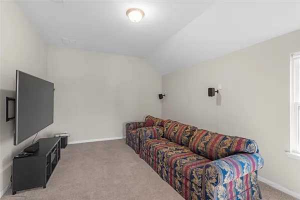 a living room with furniture a flat screen tv and gym equipment